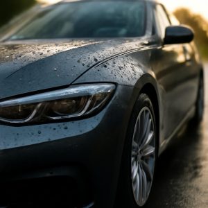 Автомобиль с керамическим покрытием на мокрой дороге, демонстрирующий гидрофобность